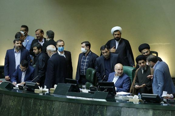 Iranian lawmakers mingle at the presidium stage of parliament.