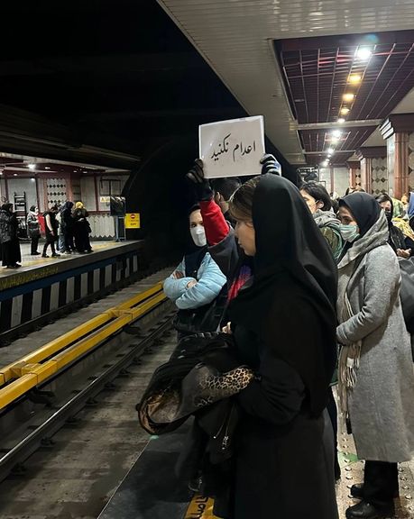 پلاکارد «اعدام نکنید» در دست زنی در متروی تهران