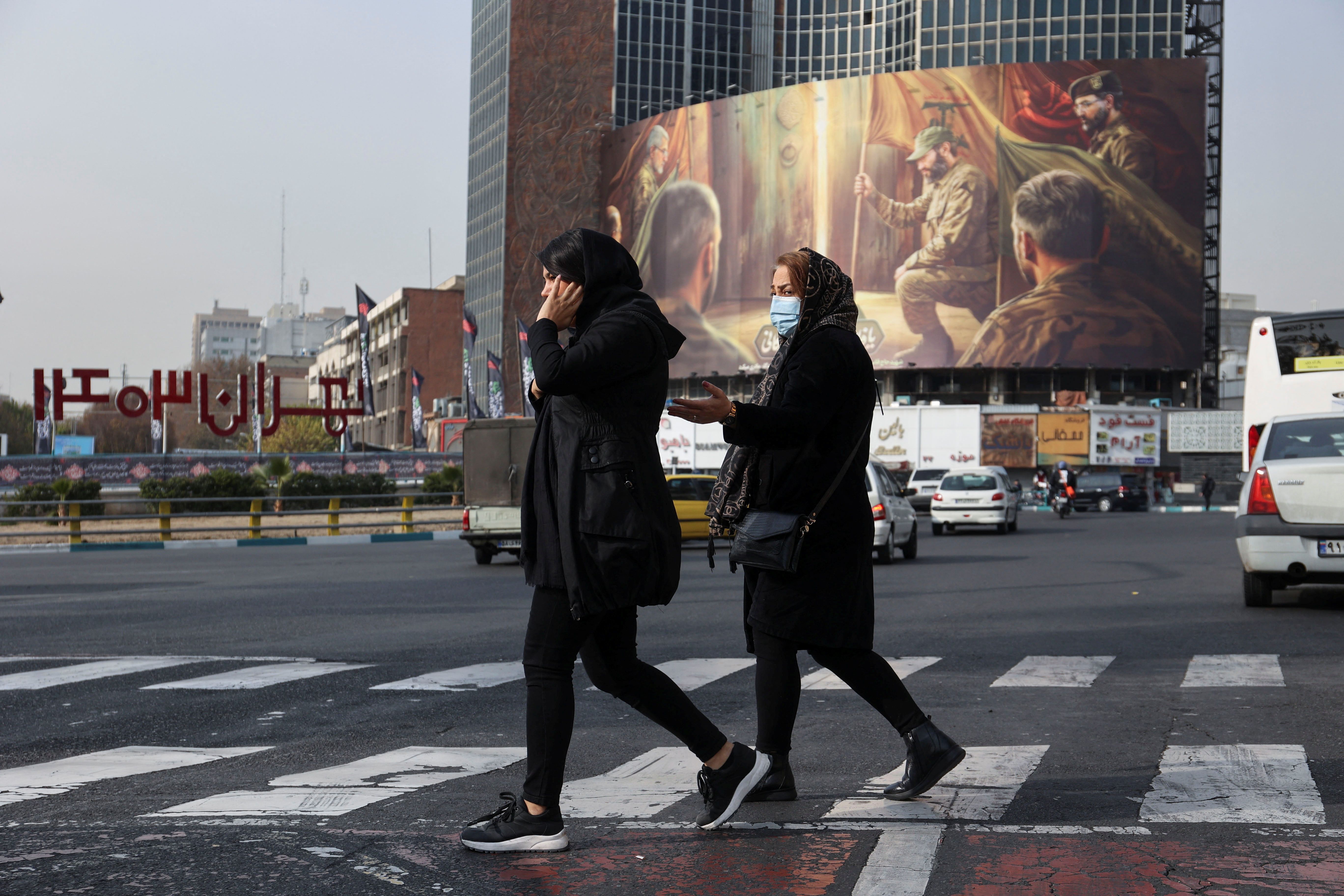 Iranians walk next to a pro-Hezbollah billboard on a street in Tehran, Iran December 8, 2024. 