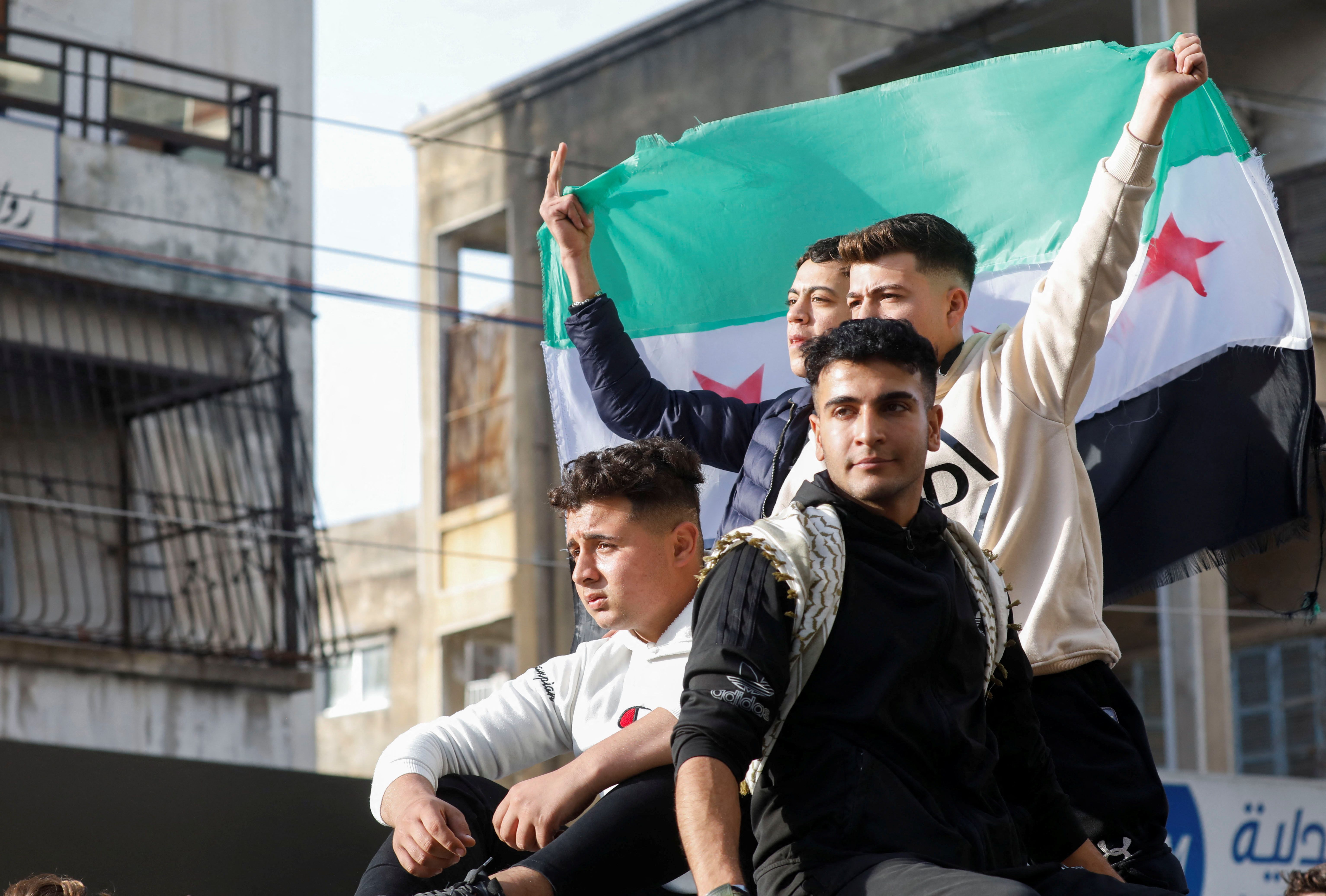 Young Syrian men celebrating the fall of Bashar al-Assad