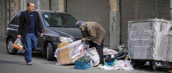 An Iranian man walking past a waste picker on the streets of Tehran