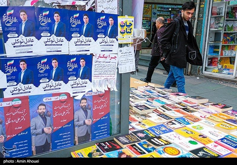 An Iranian man walks past campaign posters for the parliamentary election in Tehran, February 2024