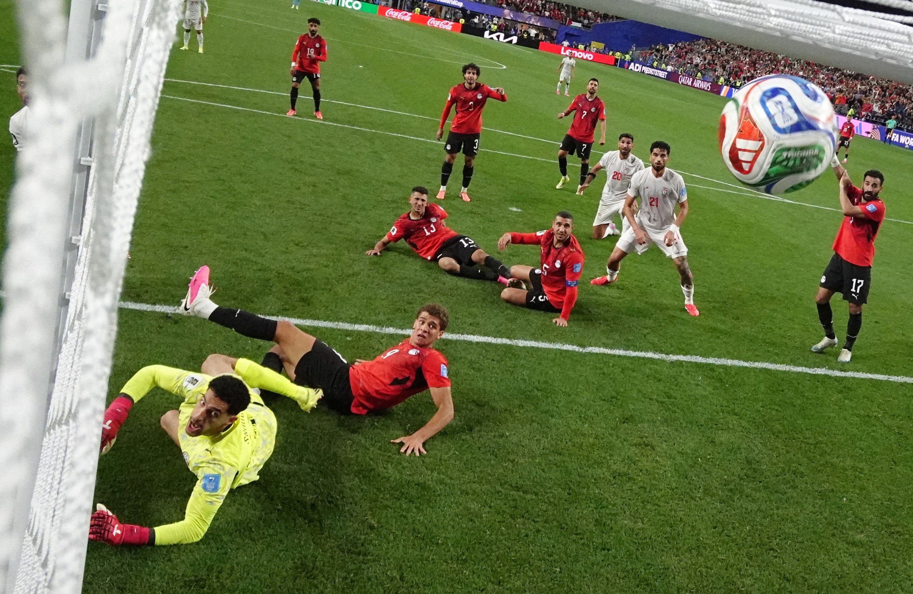 Iran's Shoja Khalilzadeh scores a goal past Egypt's Mostafa Shoubir that was later disallowed.  