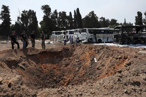 Police officers stand next to a crater at an impact site following a missile attack from Iran, in Herzliya, Israel, June 17, 2025.