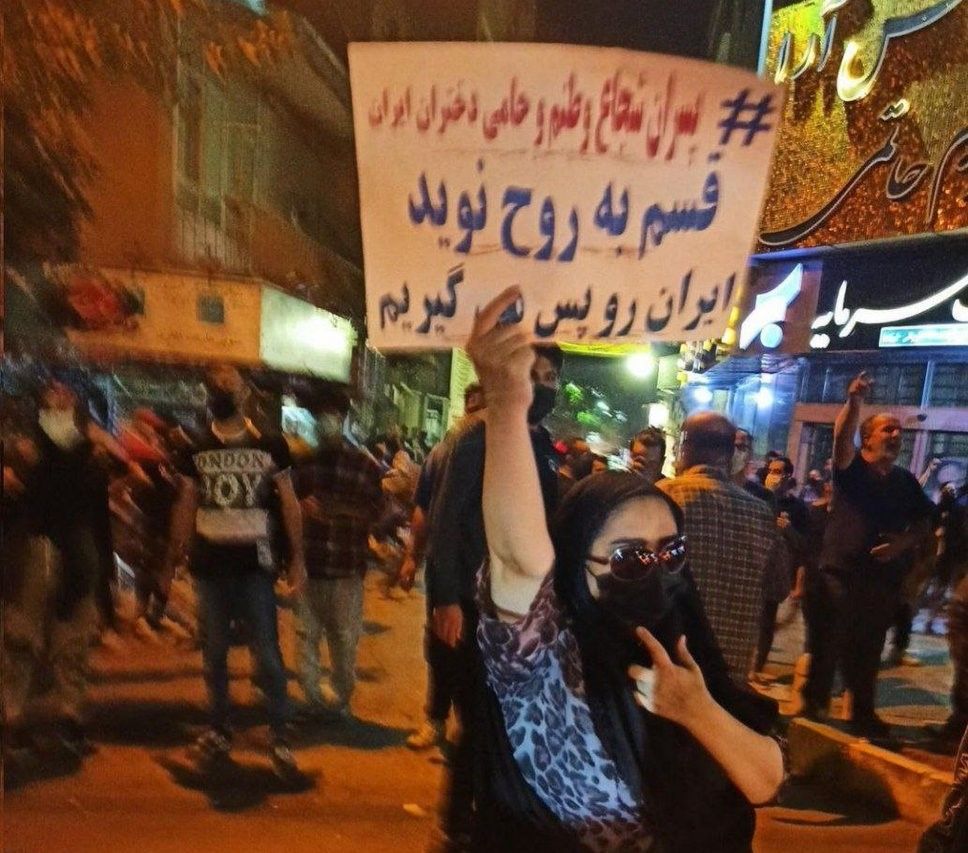 A woman holding a sign in Tehran that says "Brave boys in my country are guardians of Iran's women". October 15, 2022