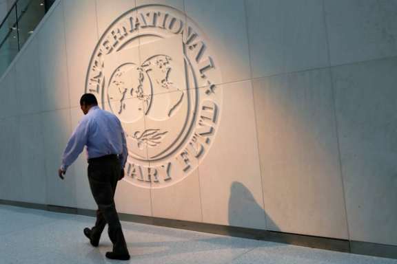 A man walks past the International Monetary Fund (IMF) logo at its headquarters in Washington, US, May 10, 2018.