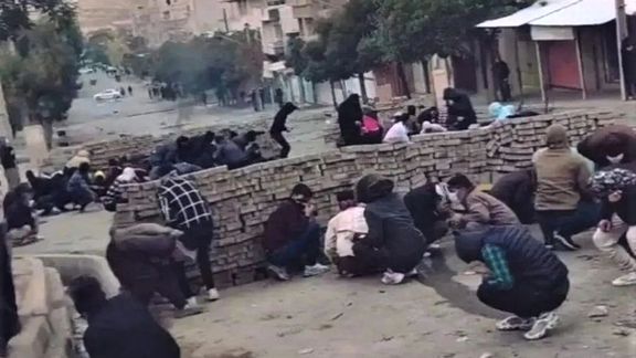 Kurdish civilian protesters hiding behind a makeshift barricade on Nov, 19, 2022