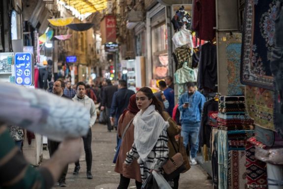 An Iranian young woman looks on as she and her mother walk along an area in Tehran Grand Bazaar (Market), December 3, 2022.