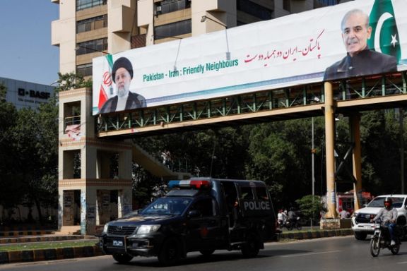 Vehicles move past a pedestrian bridge with a billboard displaying the photos of Iranian President Ebrahim Raisi and Pakistan's Prime Minister Shehbaz Sharif, as the Iranian President arrived on a three-day official visit in Karachi, Pakistan April 22, 2024.