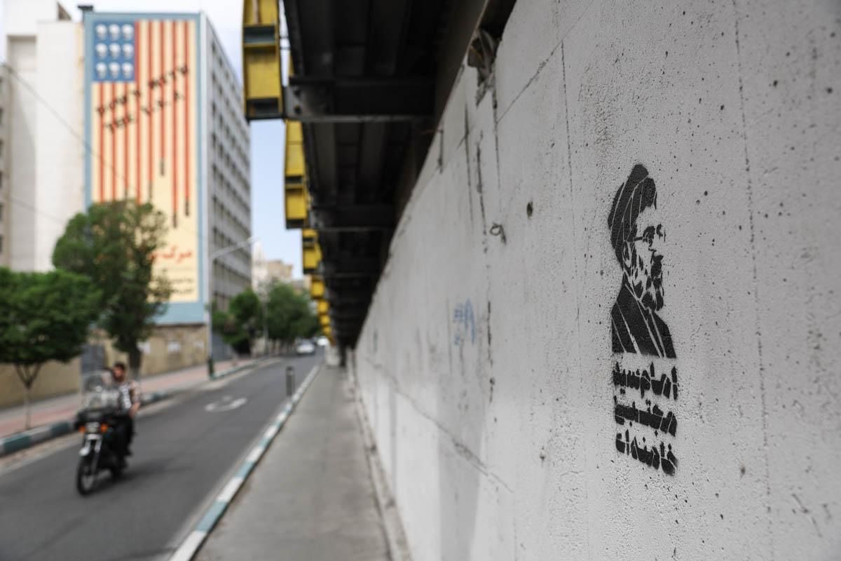A graffiti of Iran's supreme leader Mojtaba Khamenei with an anti-US mural in the background, Tehran, May 8, 2026