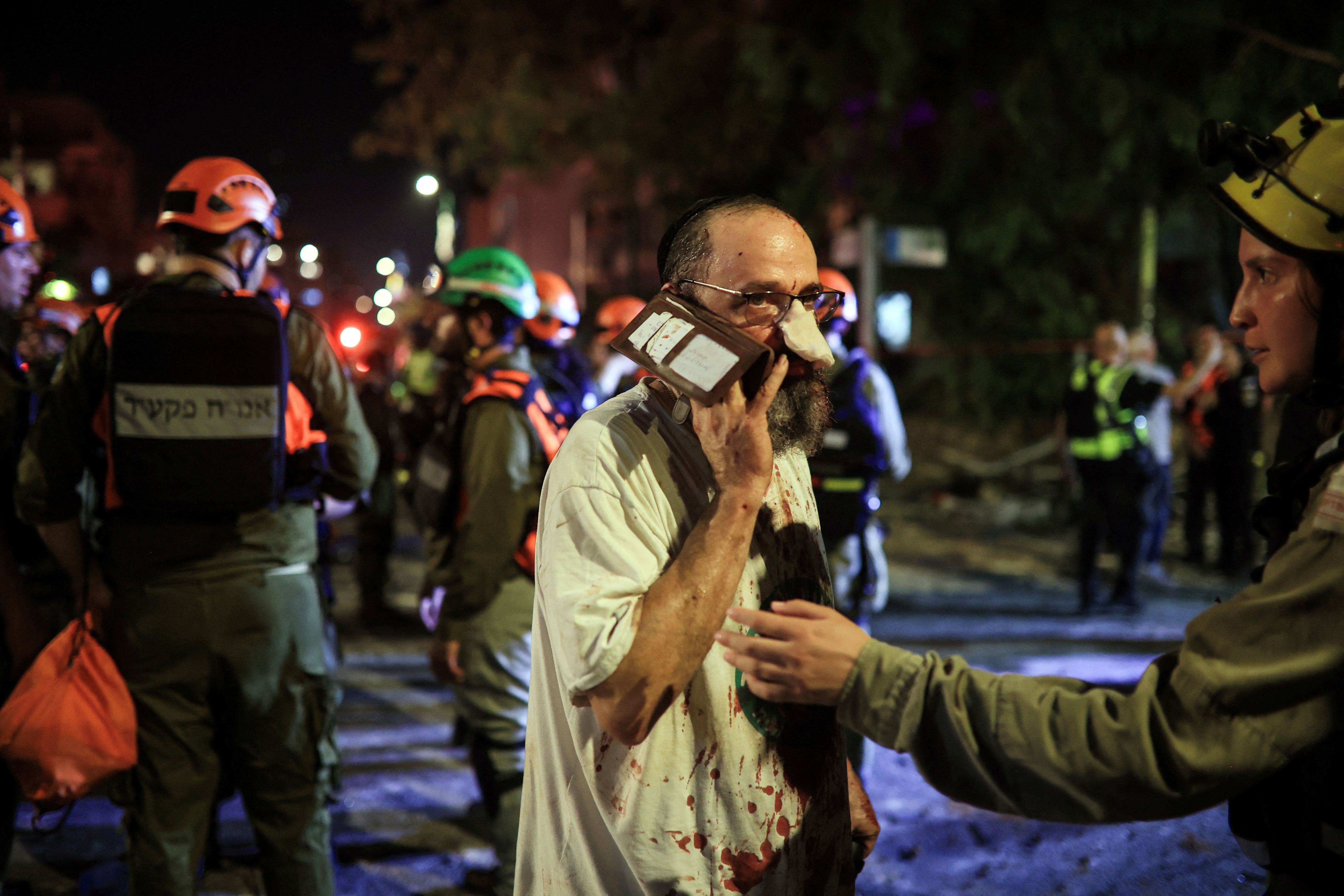 Rescue and security personnel attend a wounded person at an impact site following missile attack from Iran on Israel, in Ramat Gan, Israel June 13, 2025
