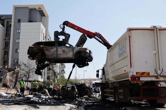 A crane lifts a destroyed car at an impact site following Iran's missile strike on Israel, in Be'er Sheva, Israel, June 20, 2025.