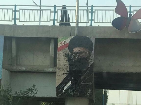 A large poster of Supreme Leader Ali Khamenei splashed with black paint in Tehran in October 2022