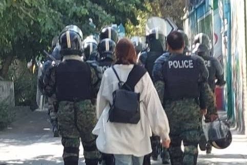 A woman walking without a hijab next to police officers, an unimaginable scene just 2 weeks ago