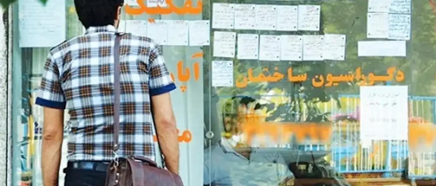A young man checking the rents in front of a real estate office in Tehran