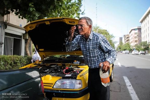 Iranian taxi drivers splash water on themselves to cool down during the heat surge in Tehran, August 2, 2023.
