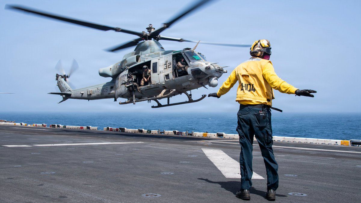 A US sailor directs the takeoff of a UH-1Y Venom utility helicopter from the flight deck of USS Boxer (LHD 4) as the amphibious assault ship sails in the Arabian Sea. (CENTCOM)
