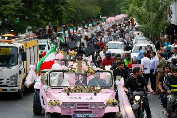 Couples ride in a decorated pink vehicle during a marriage-themed procession linked to pro-government rallies in Tehran.