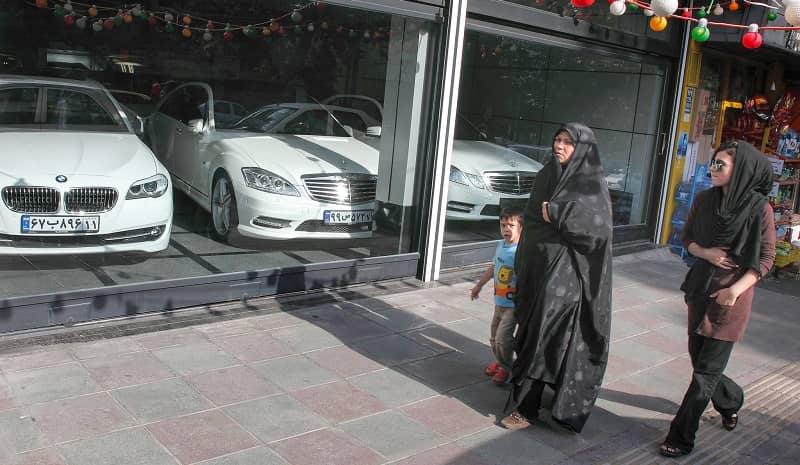 People passing by a shop for luxury cars in Tehran   