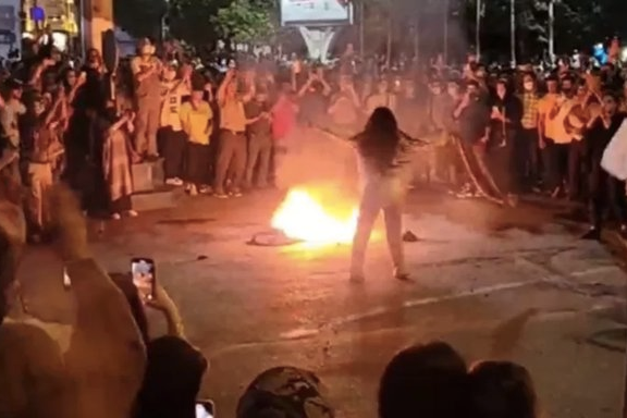 Iranian women burning headscarves during protests as a symbolic move against the compulsory Islamic dress code or hijab
