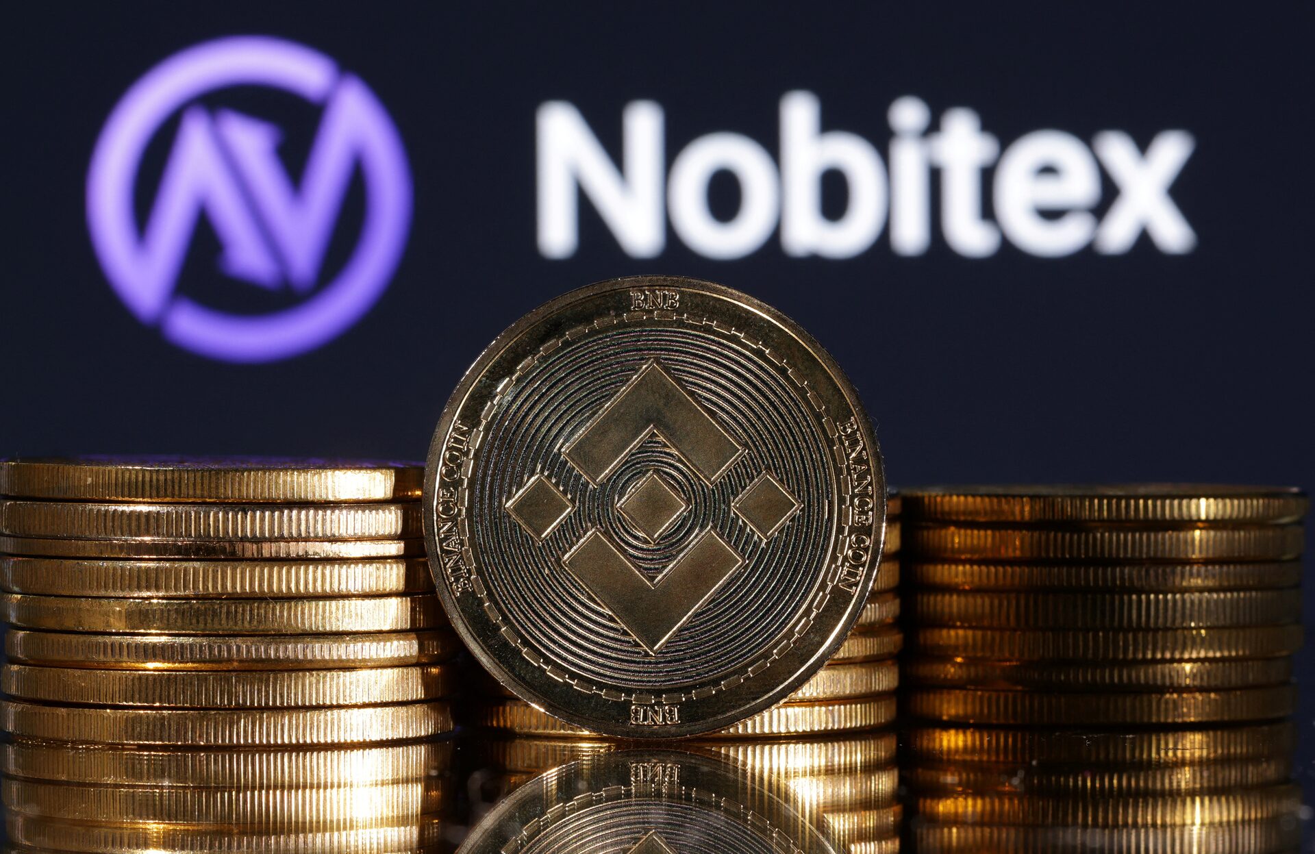 Representations of cryptocurrency Binance are seen in front of displayed Nobitex logo in this illustration taken November 3, 2022
