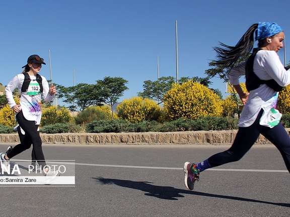 Two women running at a marathon race in Shiraz