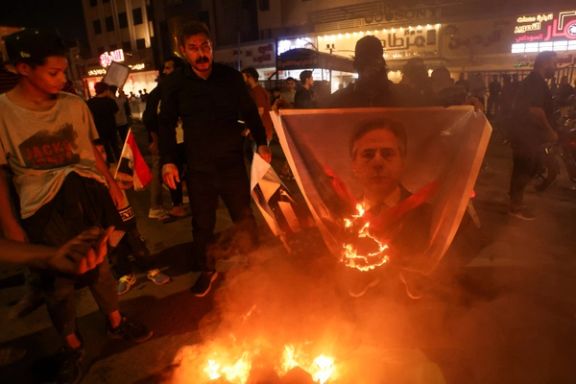 A person burns a picture of US Secretary of State Antony Blinken as supporters of Iraqi Shiite cleric Moqtada al-Sadr protest to denounce Blinken's visit to Iraq, at Tahrir Square in Baghdad, November 5, 2023.