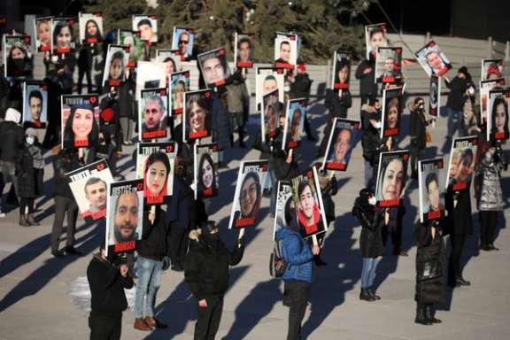 People hold placards with images of the victims of the downing of Ukraine International Airlines flight PS752 in a march to mark its first anniversary, in Toronto, Ontario, Canada January 8, 2021.