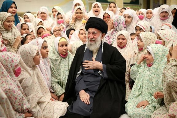 Iran’s ruler Ali Khamenei among a group of schoolgirls