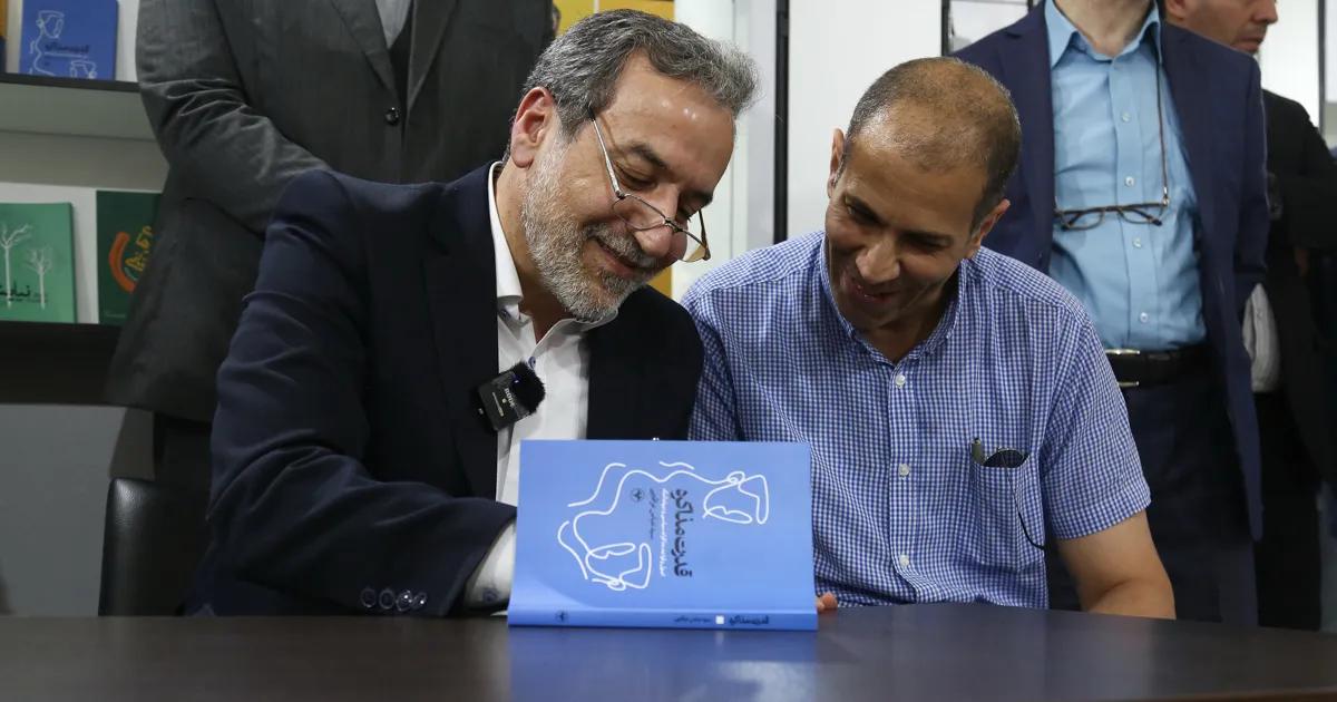 Abbas Araghchi signing a book he wrote after his removal from the Deputy Ministry of Foreign Affairs