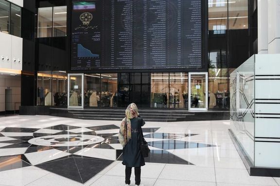A woman looks at an electronic board showing stock prices at Tehran Stock Exchange in Tehran, Iran, May 12, 2020.