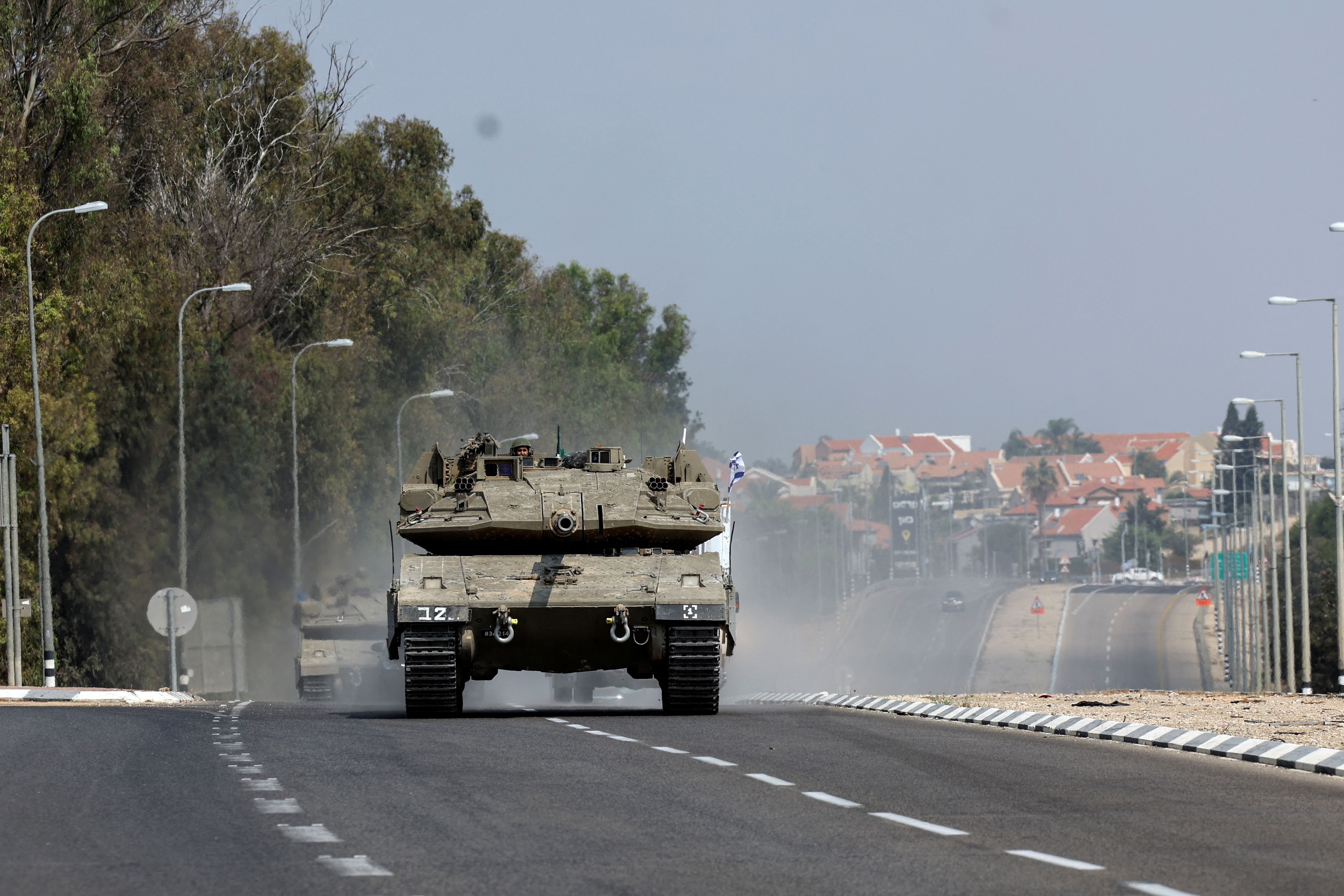 Israeli tanks drive on a road following a mass infiltration by Hamas gunmen from the Gaza Strip, near Sderot in southern Israel October 8, 2023. 