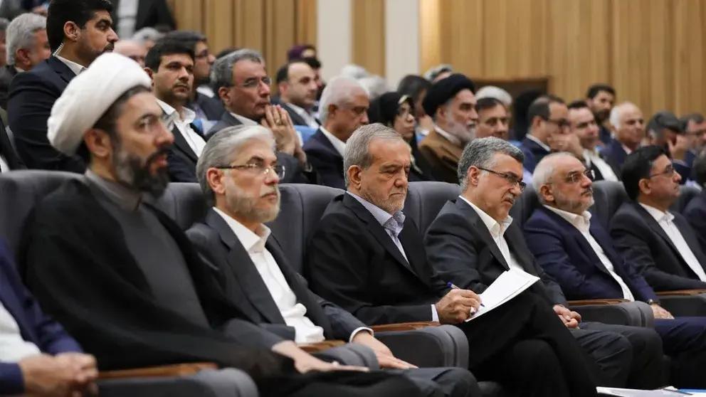 Iran's President Masoud Pezeshkian (center, taking notes) and Science Minister Hossein Simayi Sarraf (sitting to his right) during a ceremony on October 12, 2024.