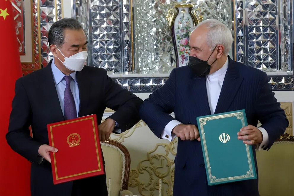 Iran's former Foreign Minister Mohammad Javad Zarif and China's Foreign Minister Wang Yi bump elbows during the signing ceremony of a 25-year cooperation agreement, in Tehran, Iran March 27, 2021.
