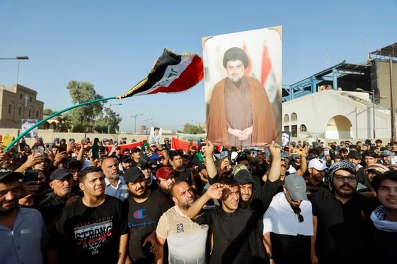 Iraqi protesters carrying a portrait of influential Shiite cleric Moqtada Sadr