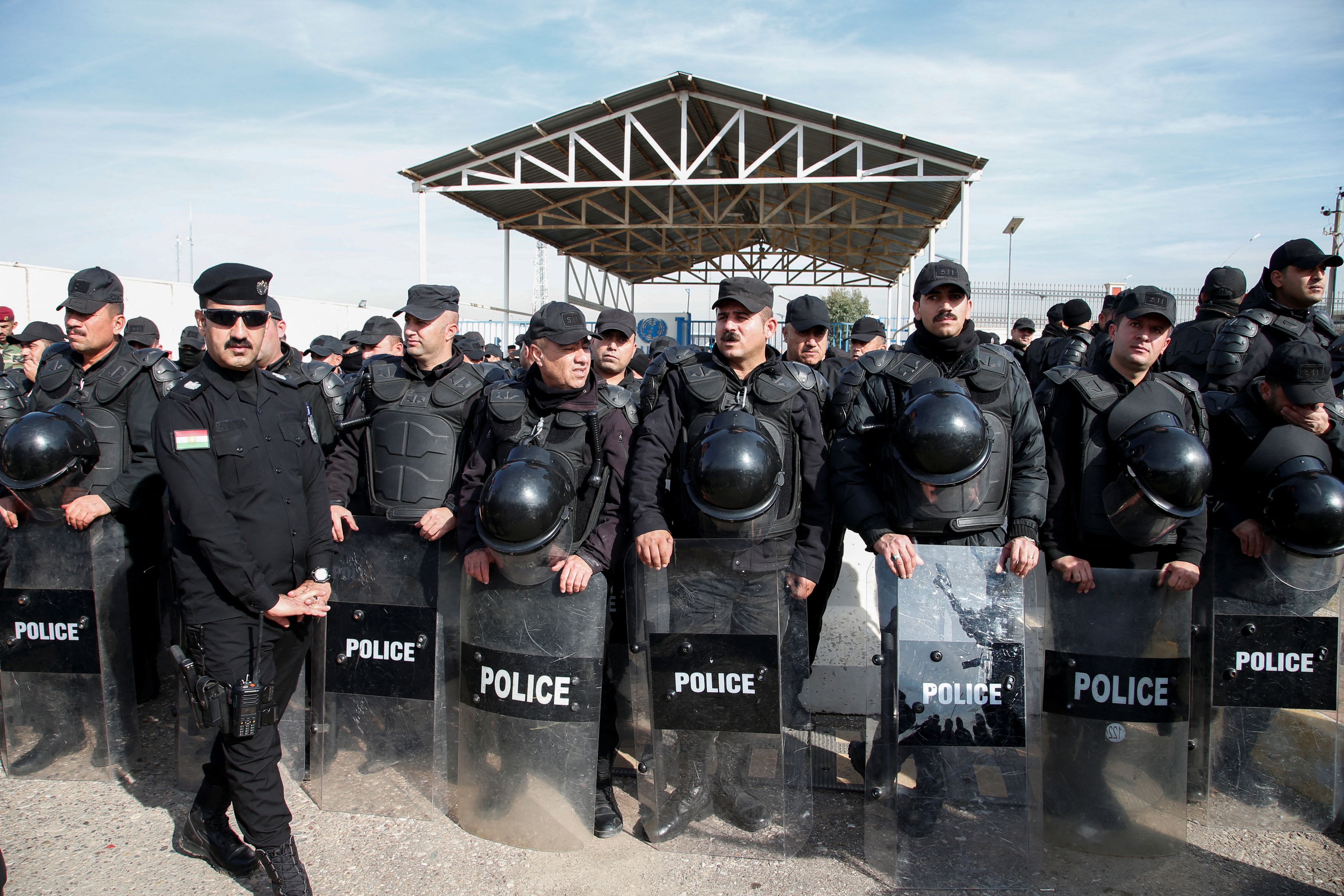 Policemen line up as people gather to demonstrate in front of the United Nations headquarters, following missile attacks by Iran's Revolutionary Guards, in Erbil, Iraq, January 16, 2024.