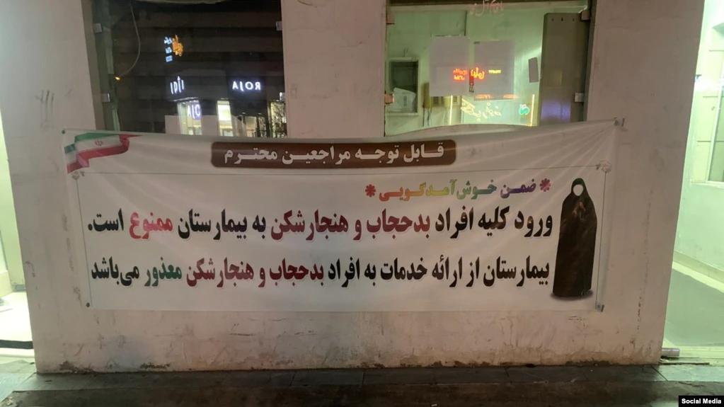 A sign outside a hospital in Iran says no medical care for women with "bad hijab", July 2023