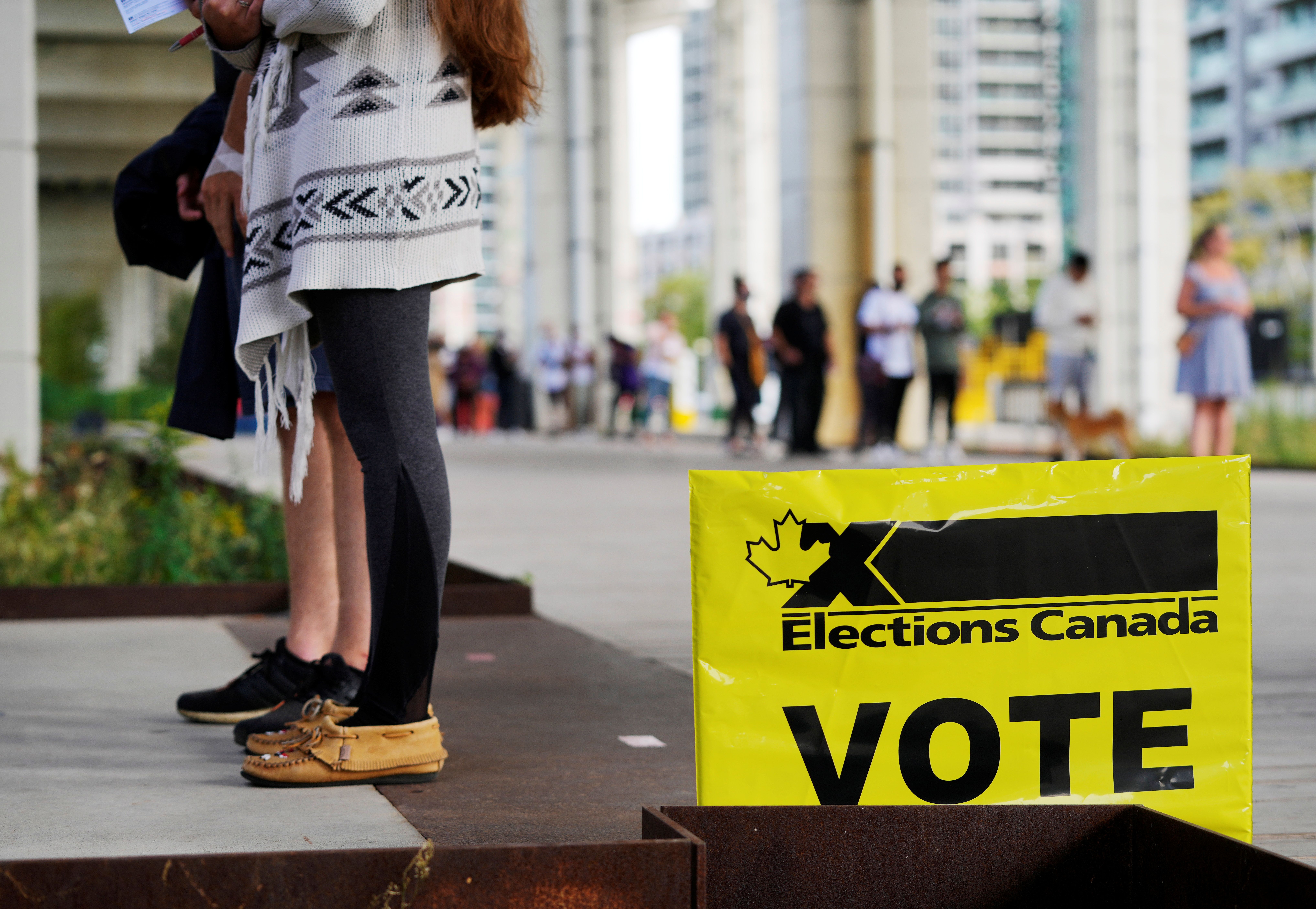 People line up outside a polling station to vote in Canada's federal election, in Toronto, Ontario, Canada September 20, 2021. 