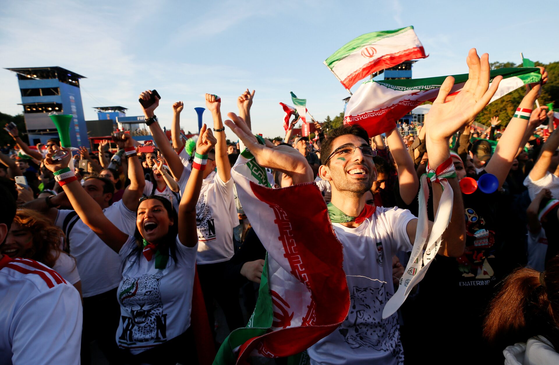 Supporters of Iran celebrate while watching the match in a fan zone.