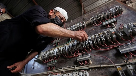 A man works on an electrical generator board during power outages in Basra, Iraq August 21, 2021.