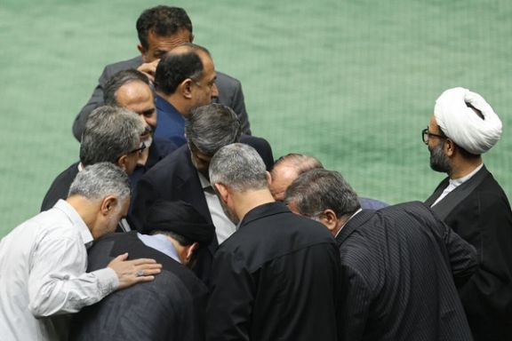 Lawmakers huddle during a session of Iran’s parliament in Tehran, Iran, October 14, 2025