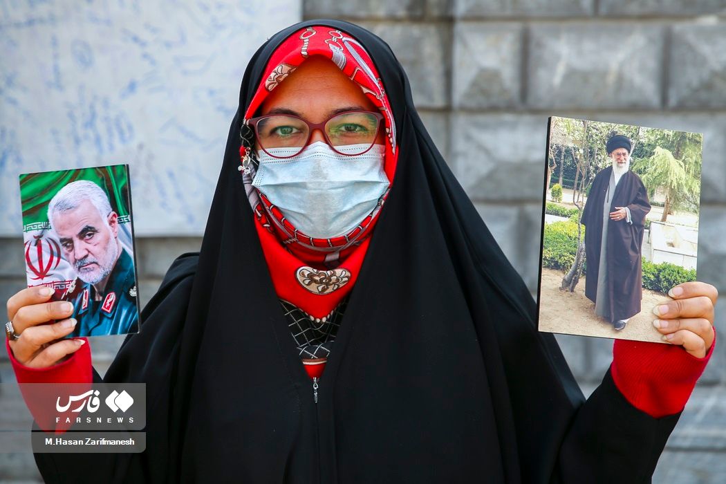 A pro-regime woman holding photos of Iran’s ruler Ali Khamenei and Qassem Soleimani, the former commander of IRGC's extraterritorial Quds Force who was killed by the US in 2020, Tehran (file photo)