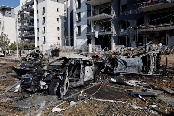 Emergency personnel work next to burnt cars and damaged residential buildings at an impact site following Iran's missile strike on Israel, in Be'er Sheva, Israel, June 20, 2025.