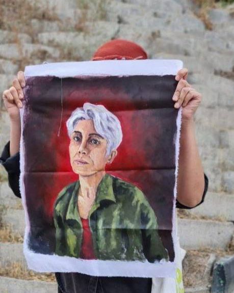 هستی امیری، پس از آزادی، تصویر پخشان عزیزی، زندانی سیاسی محکوم به اعدام را در دست گرفت