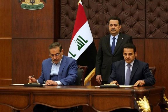 Iraqi Prime Minister Mohammed Shia al-Sudani looks on as Iraq's National Security Adviser Qasim al-Araji and Iran's Supreme National Security Council secretary Ali Shamkhani sign the security agreement that includes coordination in protecting the common borders between the two countries, in Baghdad, Iraq, March 19, 2023.