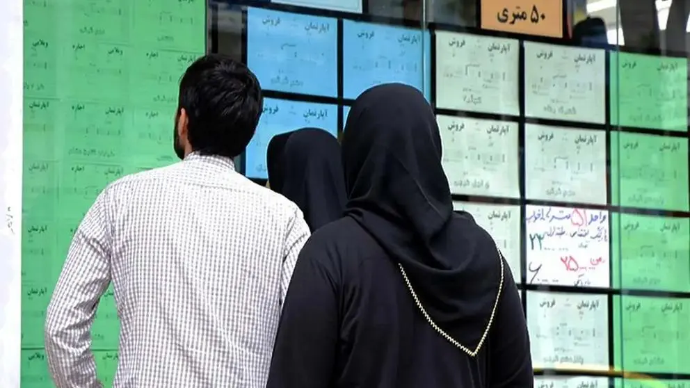 Several people looking at the ads on the door of a real estate agency in Tehran
