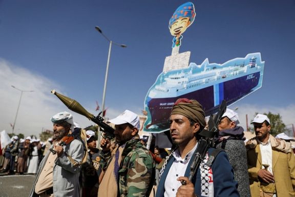 Houthis hold a cutout banner, portraying the Galaxy Leader cargo ship which they seized, during a parade. Feb. 7, 2024