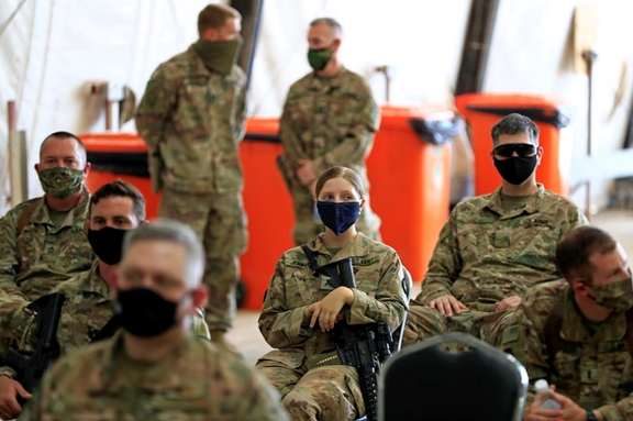 US soldiers wearing protective masks are seen during a handover ceremony of Taji military base from US-led coalition troops to Iraqi security forces, in the base north of Baghdad, Iraq August 23, 2020.