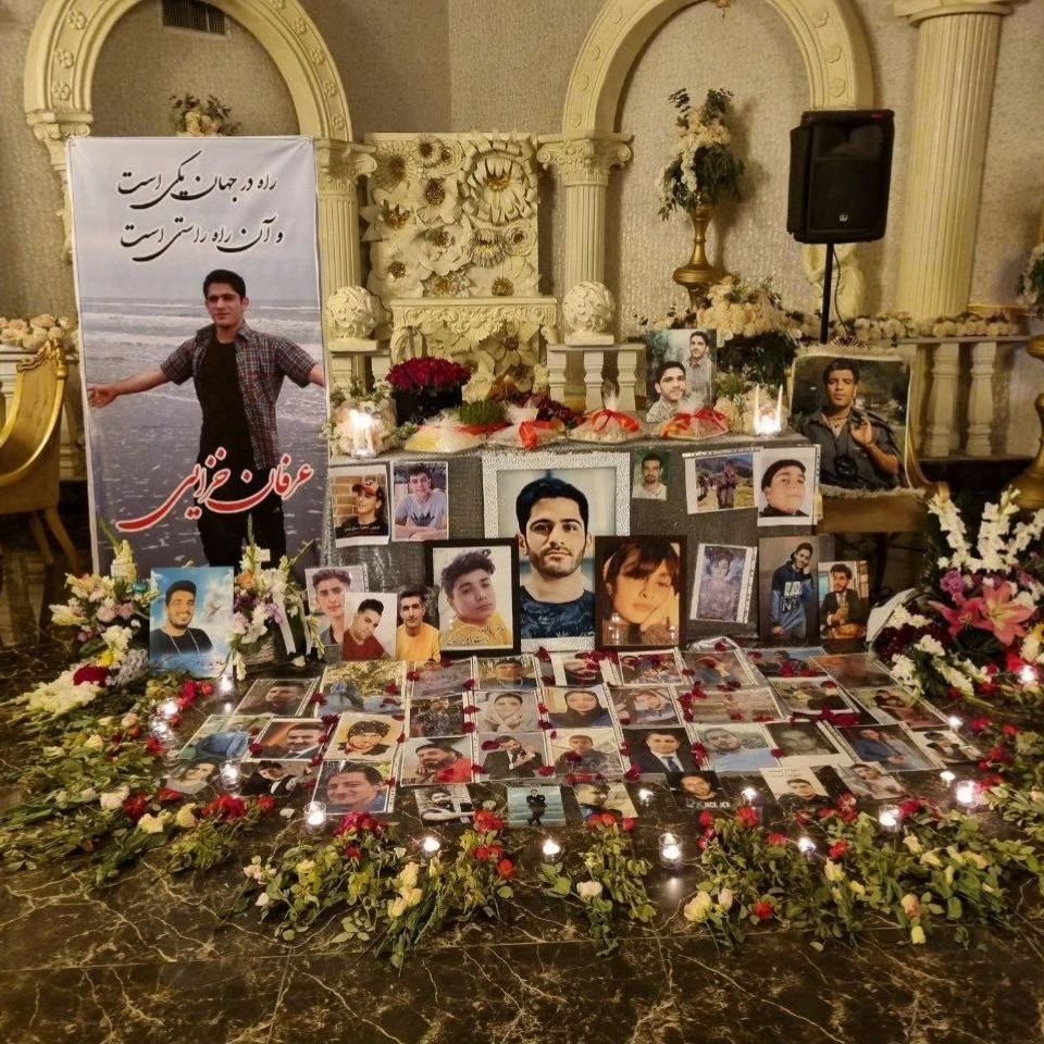 A table is adorned with photos of victims from the 2022 'Woman, Life, Freedom' movement during a memorial ceremony on September 19, 2024