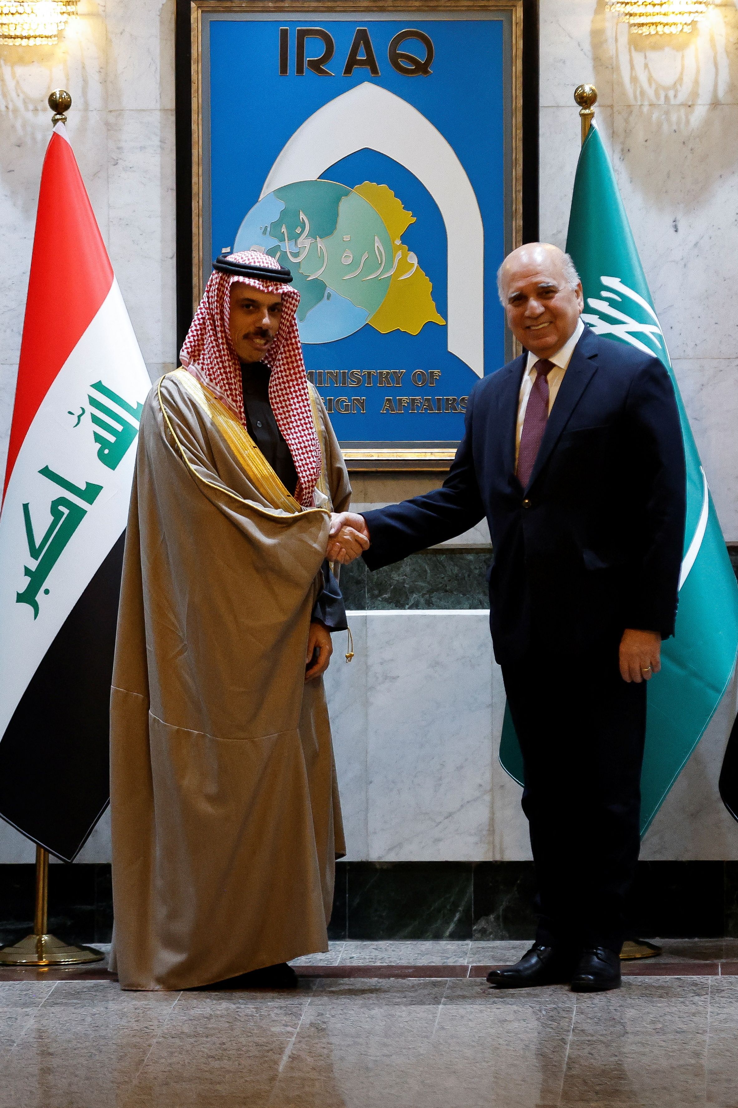 Saudi Arabia's Foreign Minister Prince Faisal bin Farhan Al Saud and Iraqi Foreign Minister Fuad Hussein shake hands, at the Ministry of Foreign Affairs in Baghdad, Iraq February 2, 2023. 